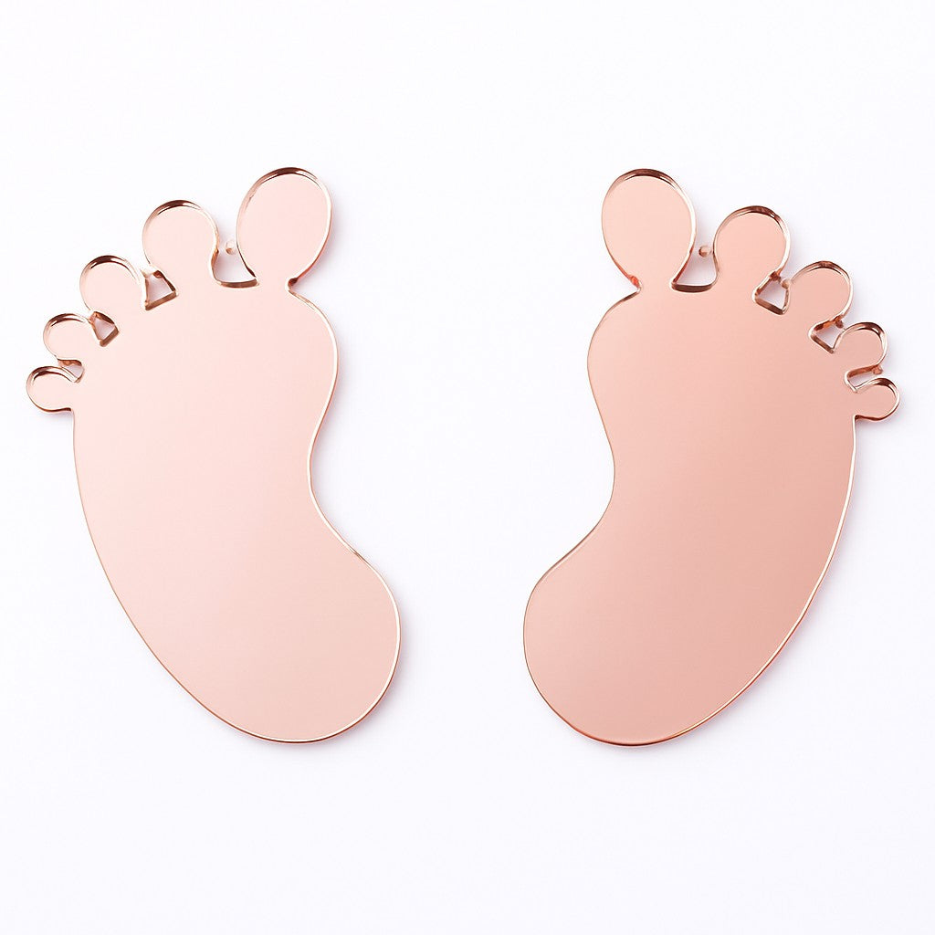 Two pink acrylic baby feet cake toppers