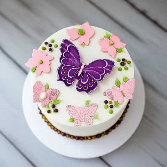 White frosted cake decorated with a purple edible butterfly topper and pink fondant butterflies, perfect for birthdays, weddings, and baby showers