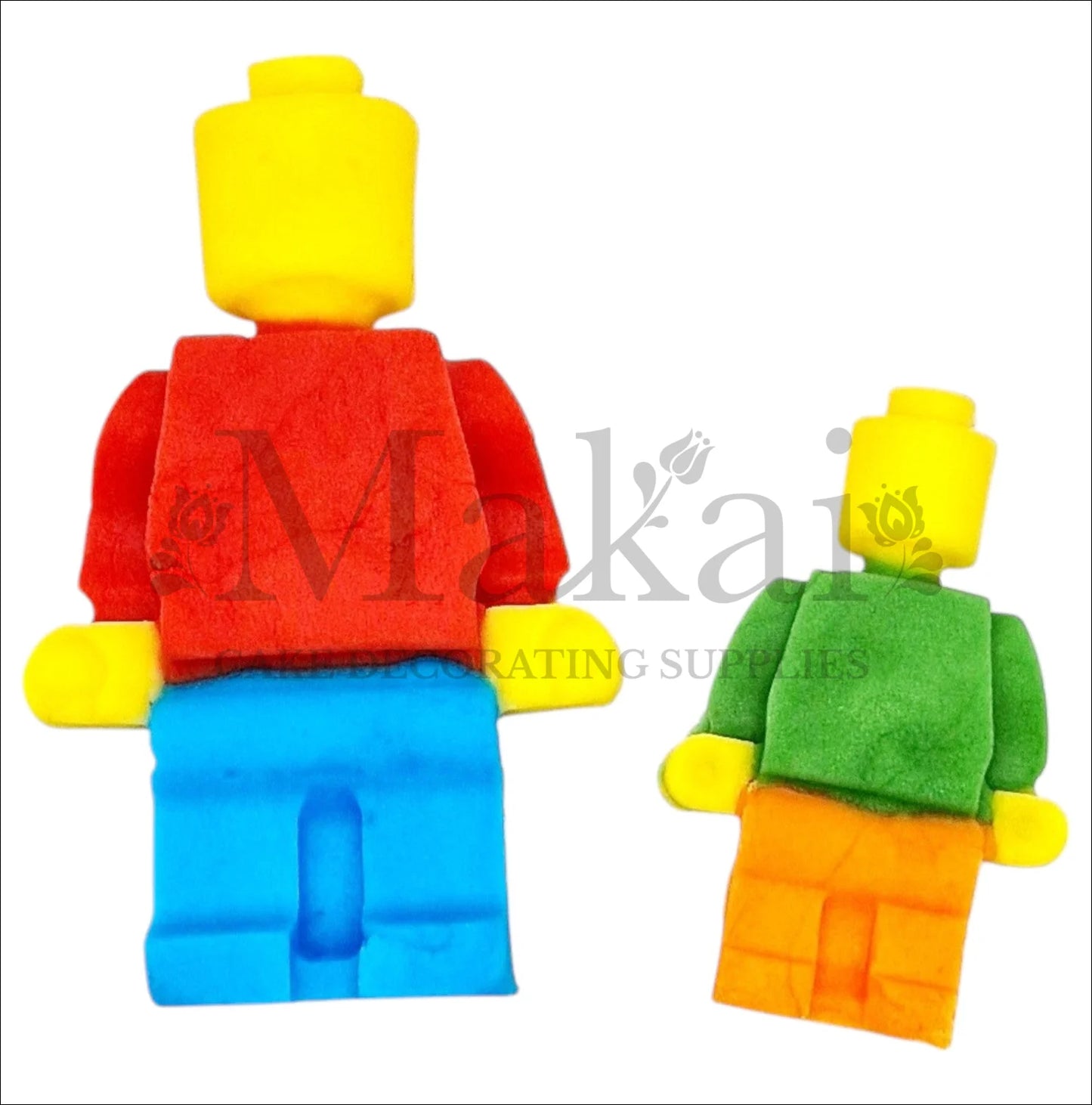 Two colourful building‑block figurine cake toppers, one large and one small, in red, blue, green, yellow and orange.