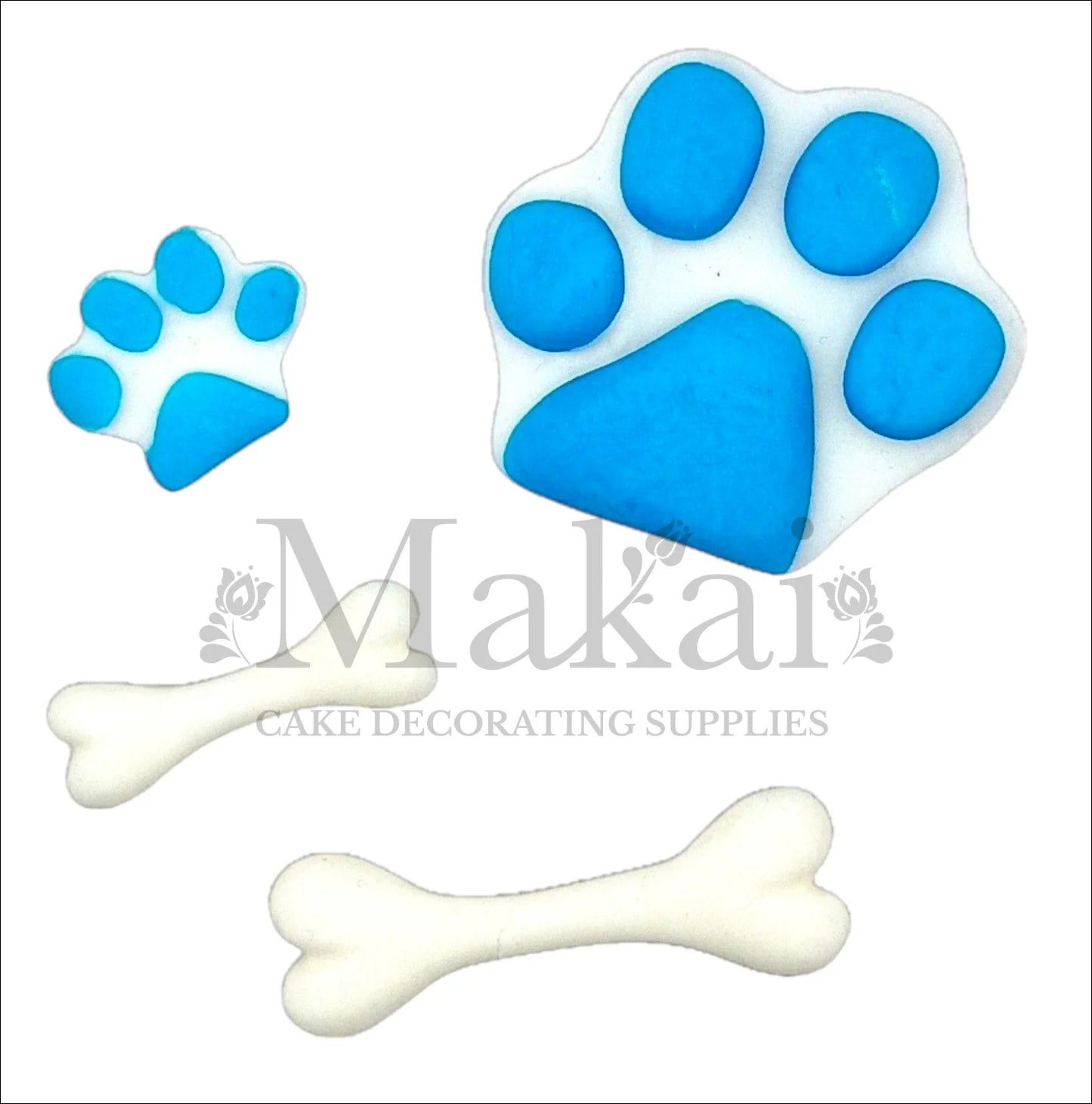 Edible fondant cake toppers of blue paw prints and white bones for animal-themed cakes.
