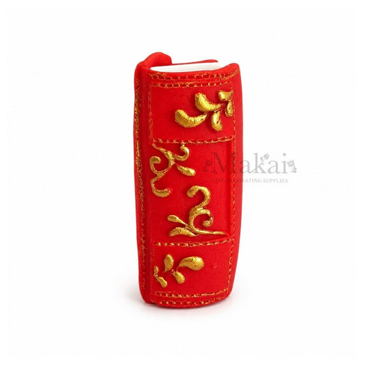 Red edible fantasy book cake topper with gold decorative details - front view