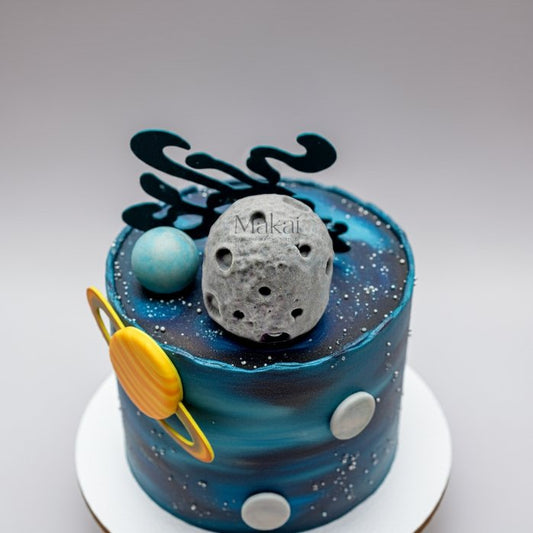 Galaxy theme cake decorated with edible moon, planets, and space topper in blue and black design.