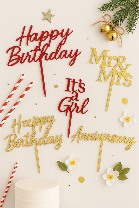 A flat lay of cake toppers for various occasions including birthday, wedding, baby shower, and anniversary, styled on a neutral background with celebratory details.
