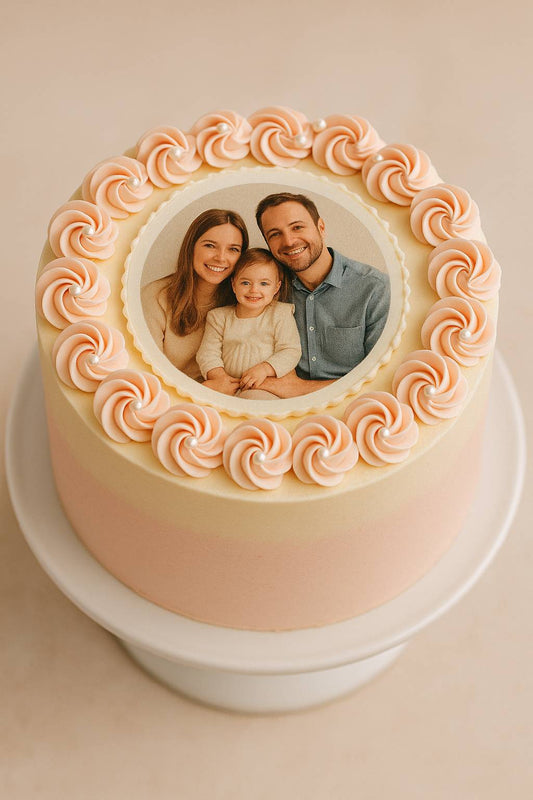 Top view of a pastel photo cake with a printed wafer card image of a family, decorated with buttercream rosettes