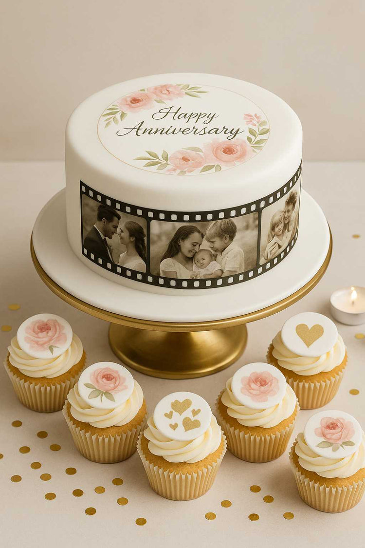Elegant anniversary cake with edible prints – white fondant cake on gold stand, decorated with floral topper, photo filmstrip, and matching cupcakes.