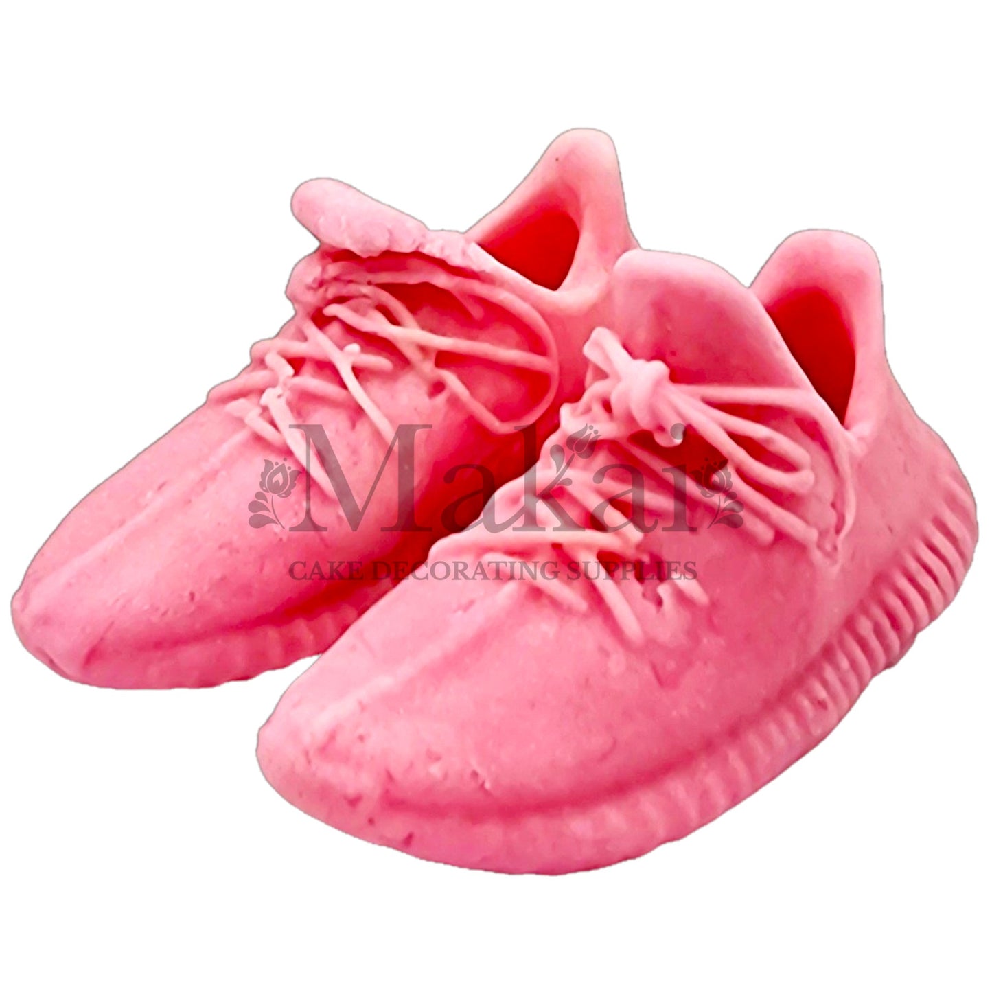 Pair of baby‑pink fondant running‑shoe toppers for sporty baby‑shower cakes.