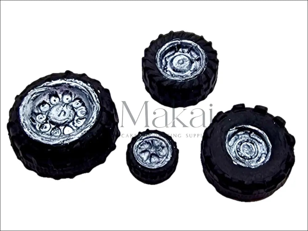 A set of four edible black vehicle wheels with a silver-painted interior, perfect for cake decorating.