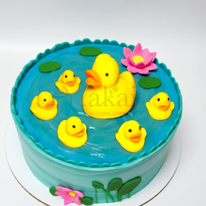 Edible 3D duck family cake decorations with mummy duck and five ducklings on a blue pond cake with pink flowers and green leaves – Makai Cake Decorating Supplies