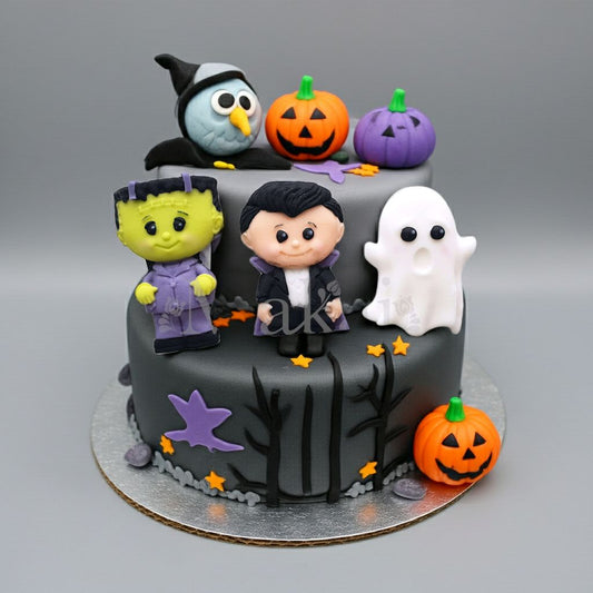 Halloween cake with fondant figures – Frankenstein, Dracula, and ghost decorations on a spooky dark grey cake with pumpkins and a witch owl. Makai Cake Decorating Supplies edible toppers.