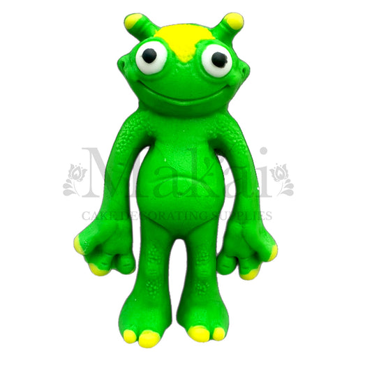 Green alien fondant cake topper with big eyes and yellow details – handmade edible decoration for space themed birthday cakes by Makai Cake Decorating Supplies