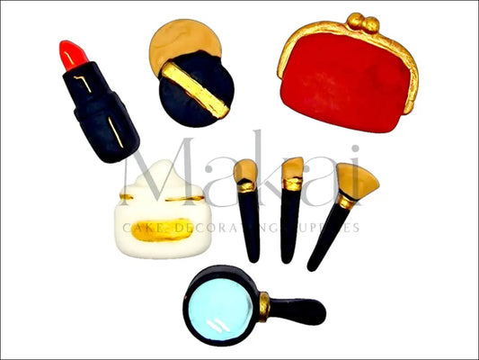 Red fondant makeup set with brushes, mirror, wallet, cream, and lipstick for cake decoration.