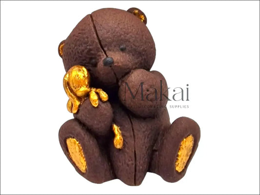 Brown edible teddy bear holding a small golden bunny, with gold details on ears, paws.