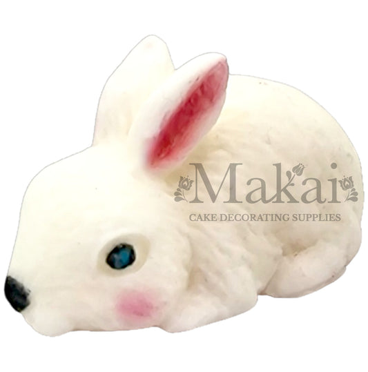Edible white lying bunny cake topper with blue eyes and pink ears