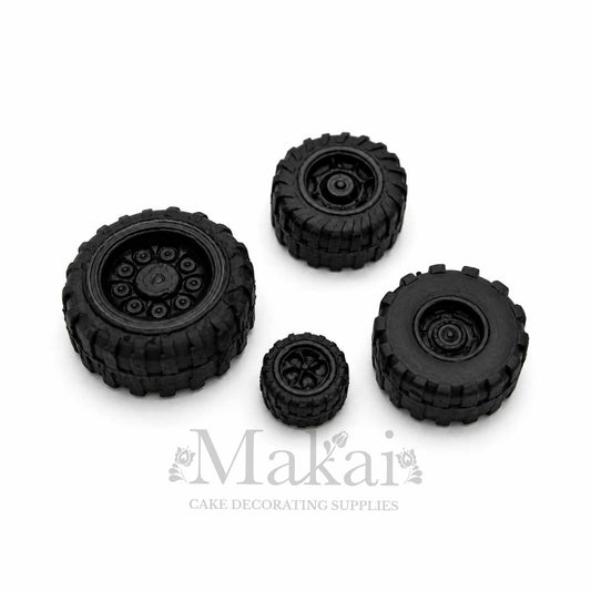 Set of four edible black fondant wheels for car, truck and motorbike cake decorations.