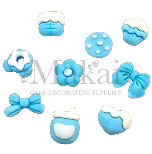 Set of ten blue fondant baby‑boy accessories—bows, bottle, cookie, cupcake and heart—for edible cake decorating.