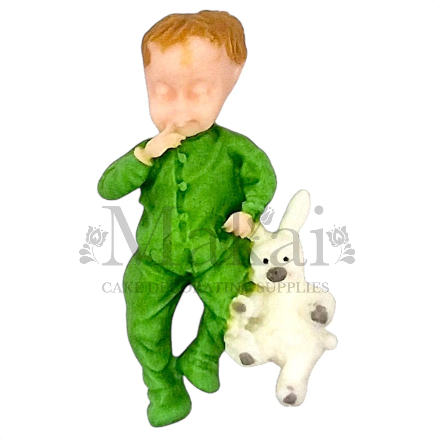 Baby boy in green pyjamas holding white bunny cake topper.