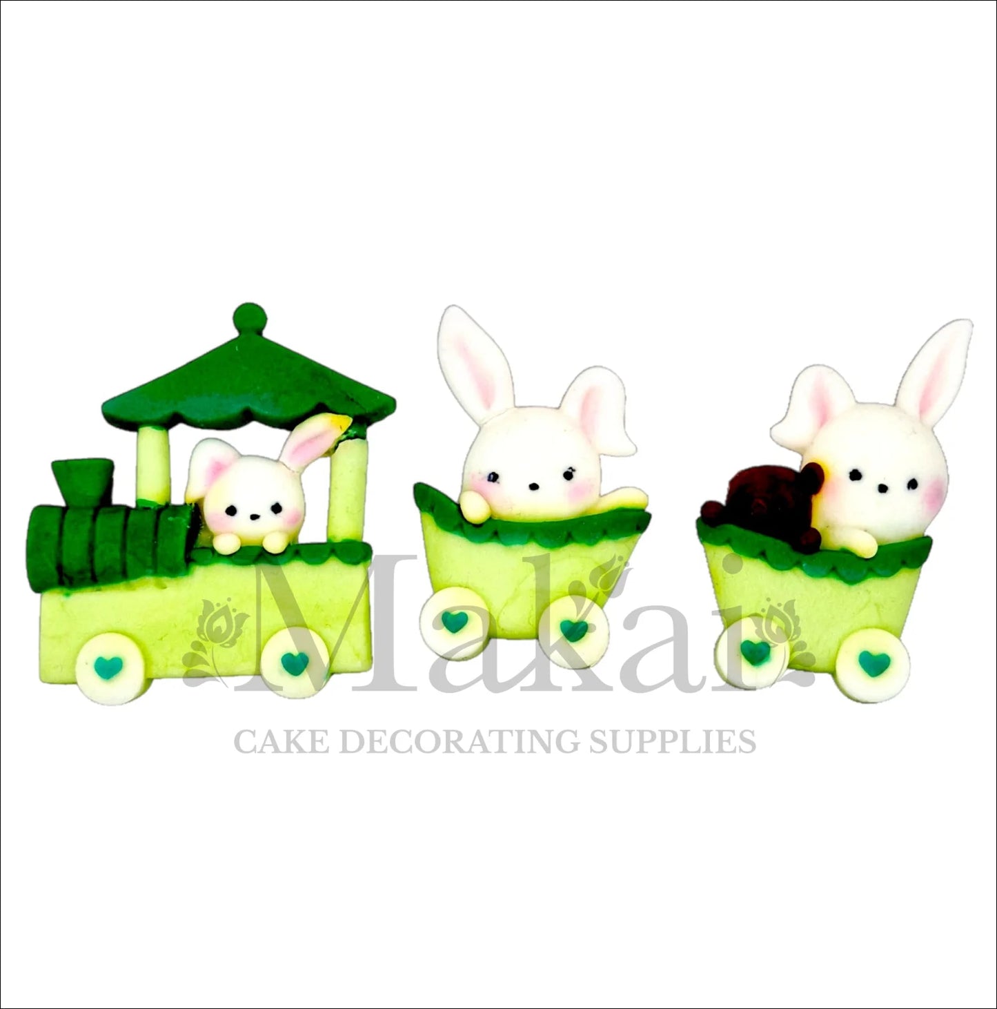Edible baby bunny train cake topper set with green locomotive and two carriages, each carrying a fondant rabbit.