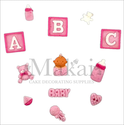 Edible baby girl cake topper set with pink alphabet blocks, bottles, teddy bear, baby face, rattle, and cute heart – perfect for baby shower or first birthday cakes.
