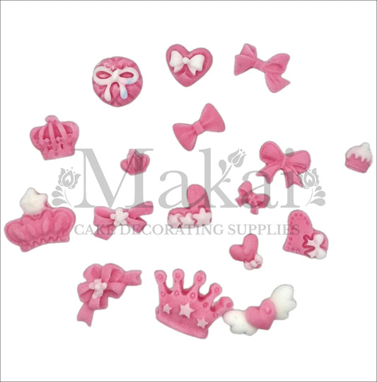 Set of edible pink fondant crowns, bows, hearts and baby accessories for princess‑themed cakes and cupcakes.