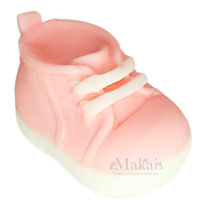 Pink baby girl shoe cake topper decoration on a white background