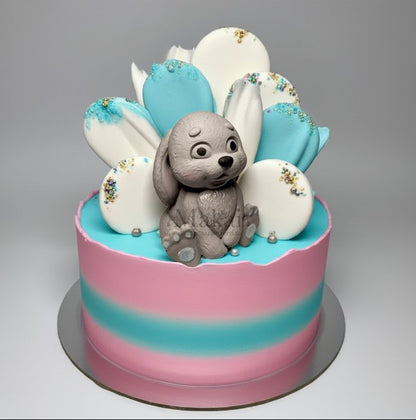 Baby shower cake with grey bunny topper and pink and blue decorations, perfect cake decorating inspiration
