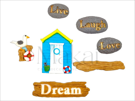 Edible beach-themed cake topper set with blue beach hut, seagull, lifebuoy, and "Live Laugh Love Dream" stones – perfect for seaside or summer cakes