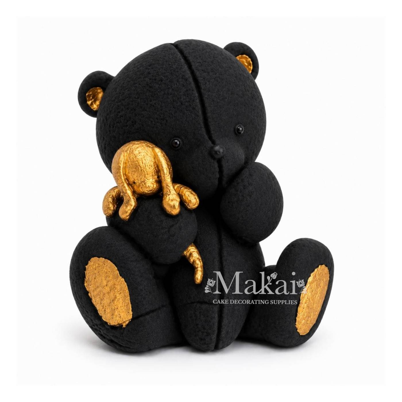 Black teddy bear fondant cake topper holding a gold bunny decoration, side view