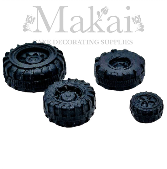 Set of four edible black fondant wheels for car, truck and motorbike cake decorations.