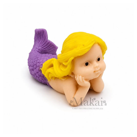 Edible lying mermaid baby cake topper with purple tail and blonde hair, perfect for ocean and fantasy-themed cakes.