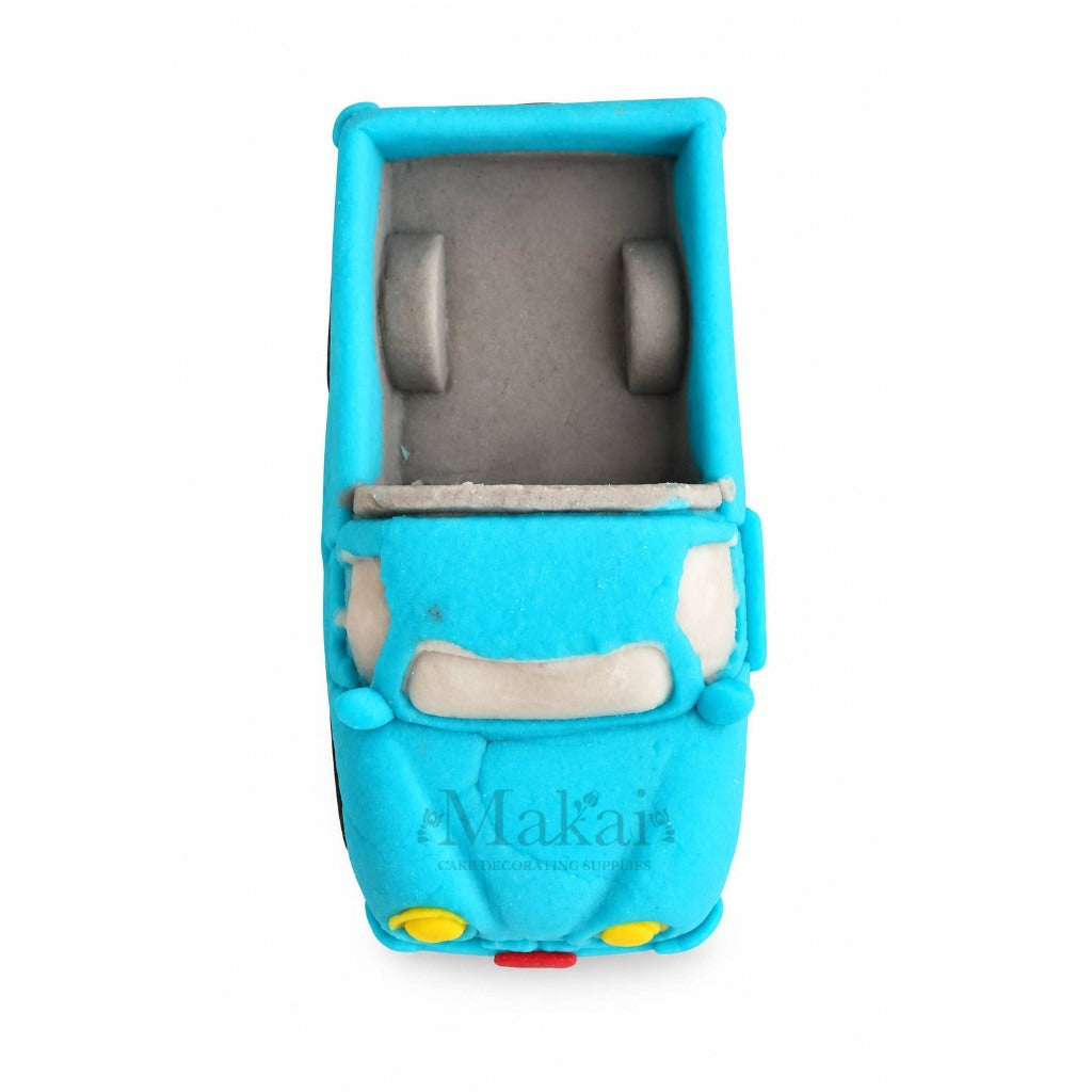 Top view of blue 3D fondant pickup truck cake topper showing the open truck bed