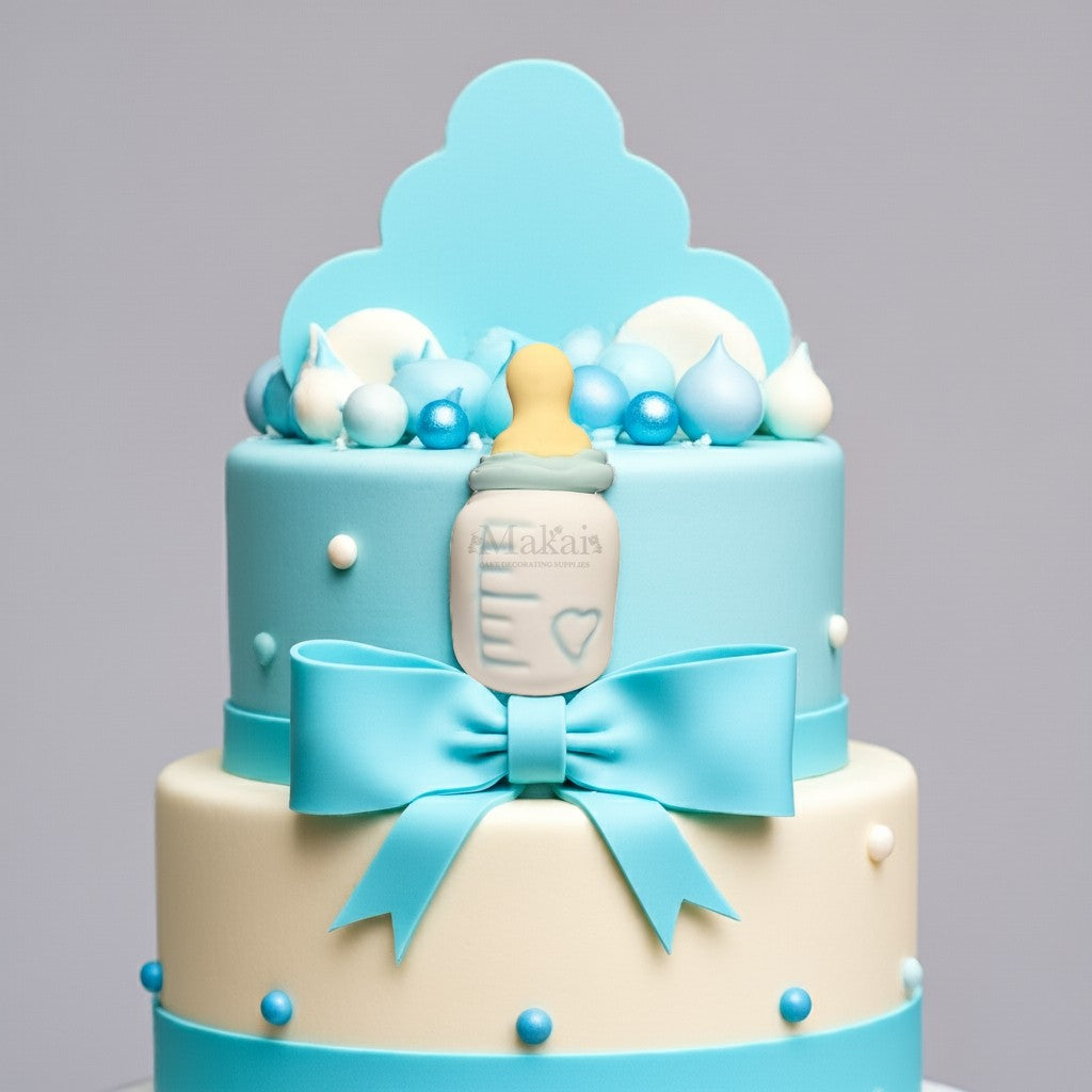 Blue and white baby shower cake decorated with fondant baby bottle topper, satin-style bow, and pastel blue sugar pearls.