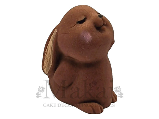 Edible brown bunny rabbit cake topper with closed eyes and blushed cheeks for woodland‑themed cakes.