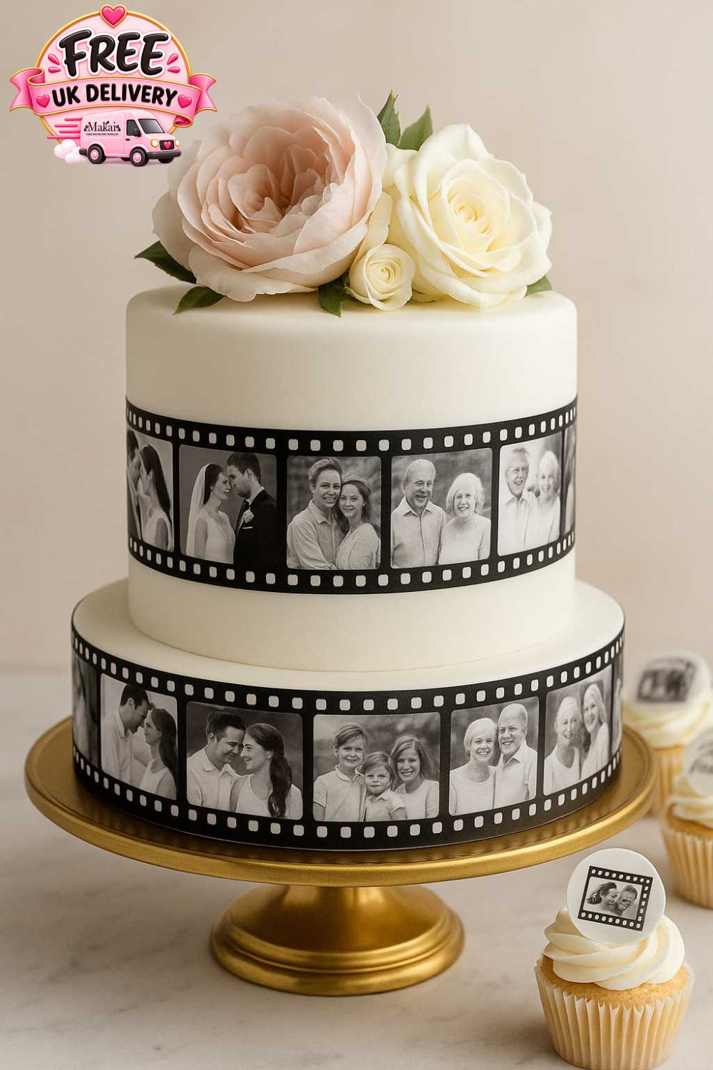 Elegant two-tier anniversary cake with white fondant, decorated with edible photo film strips and blush roses, displayed on a gold stand with matching cupcakes.