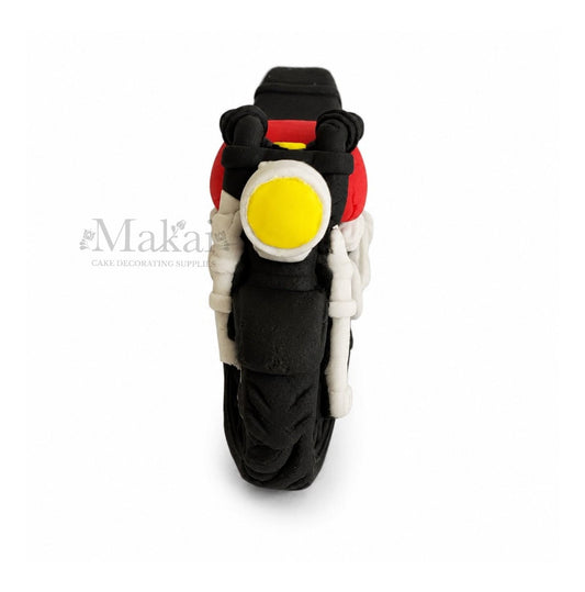 Motorcycle cake topper with a yellow light on a white background