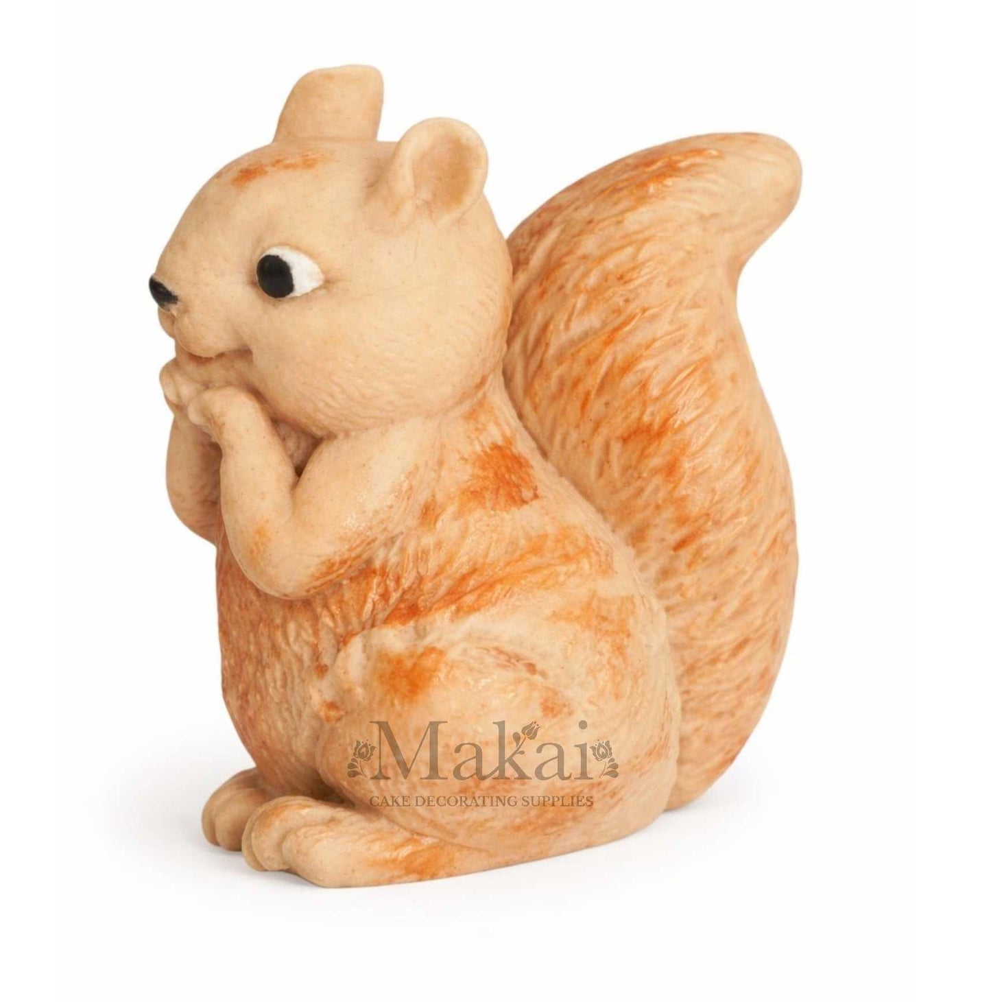 Side view of a fondant squirrel cake topper in soft cream and orange tones