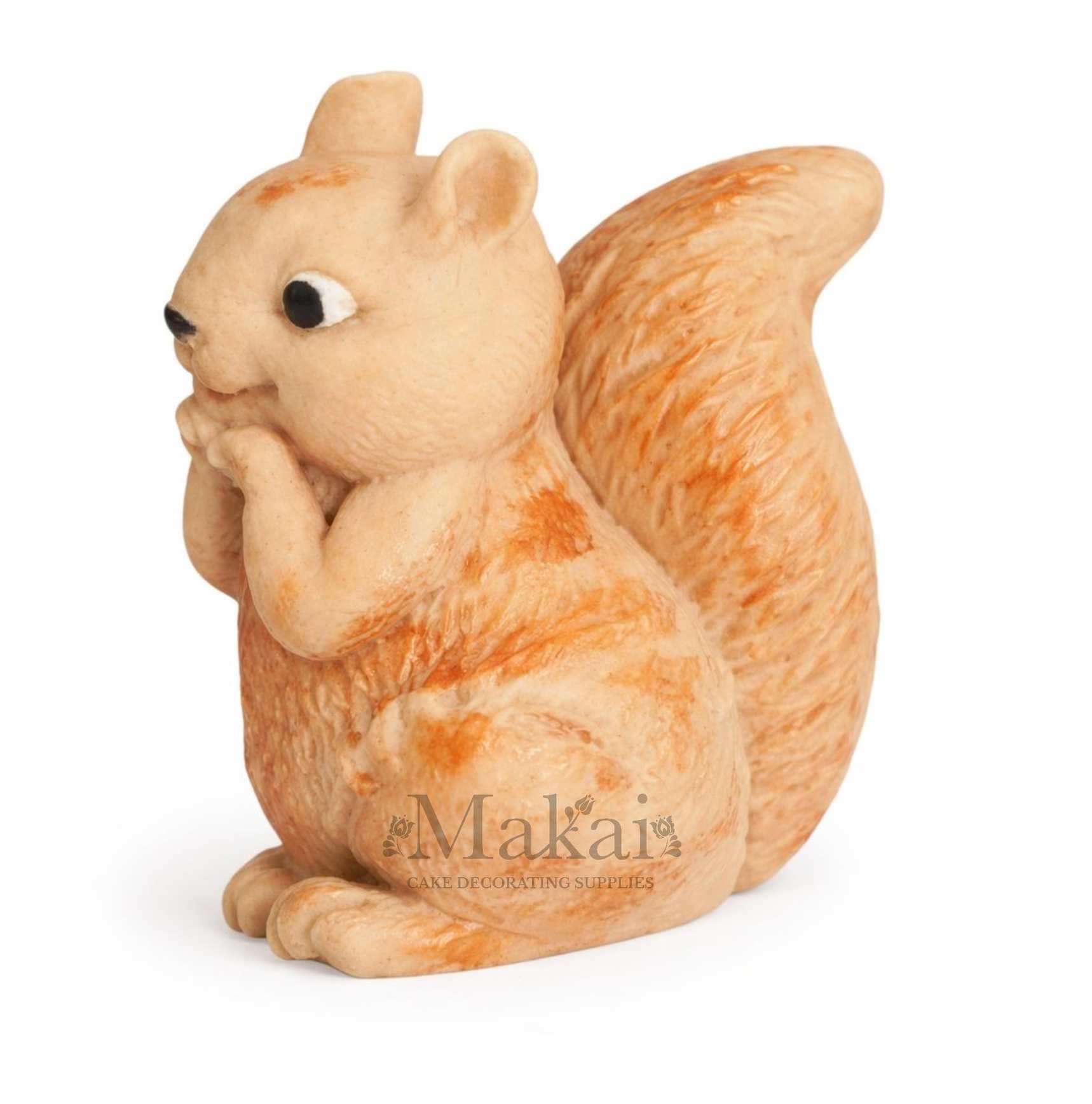 Side view of a fondant squirrel cake topper in soft cream and orange tones