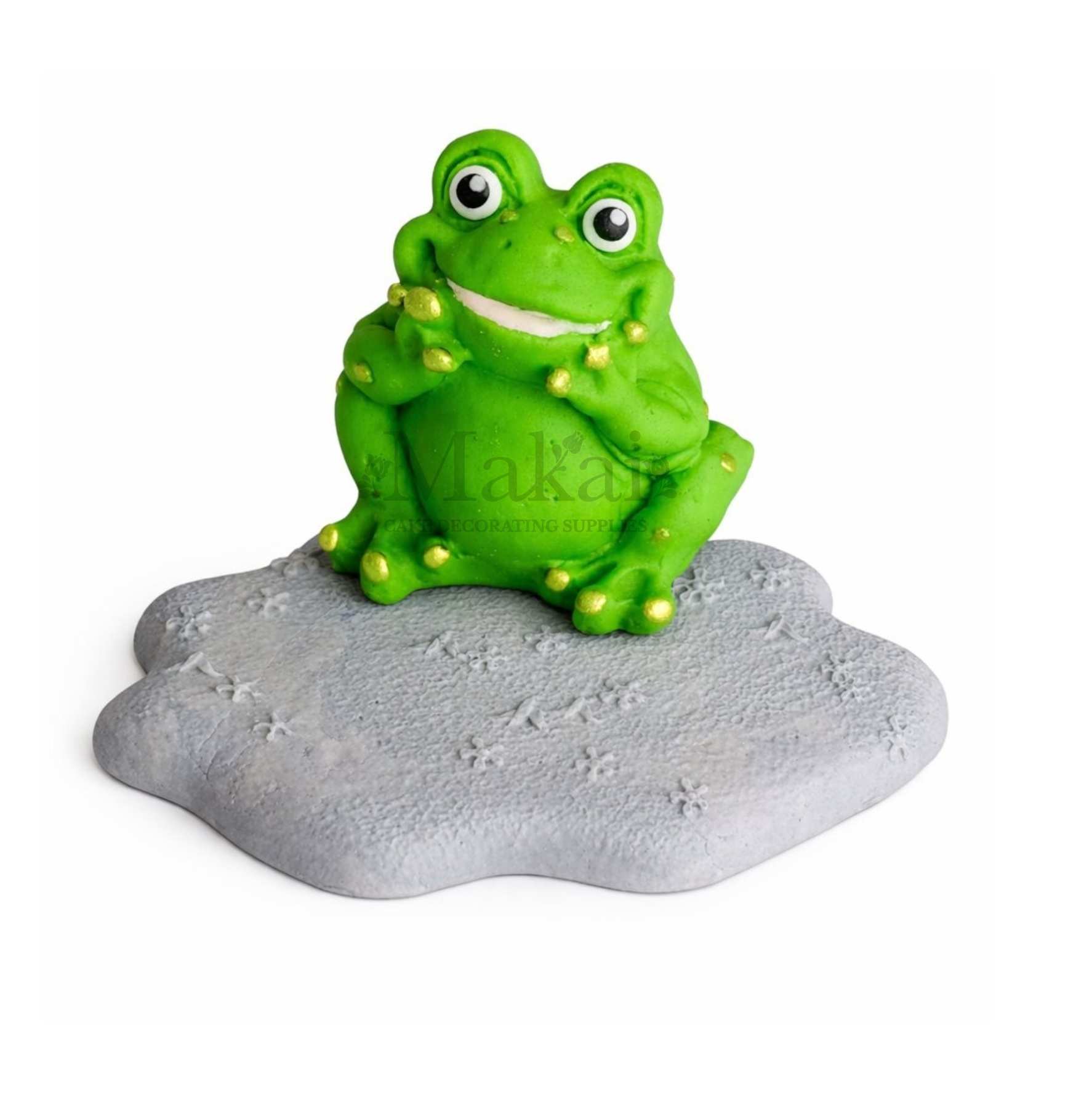 Green frog cake topper sitting on stone edible cake decoration