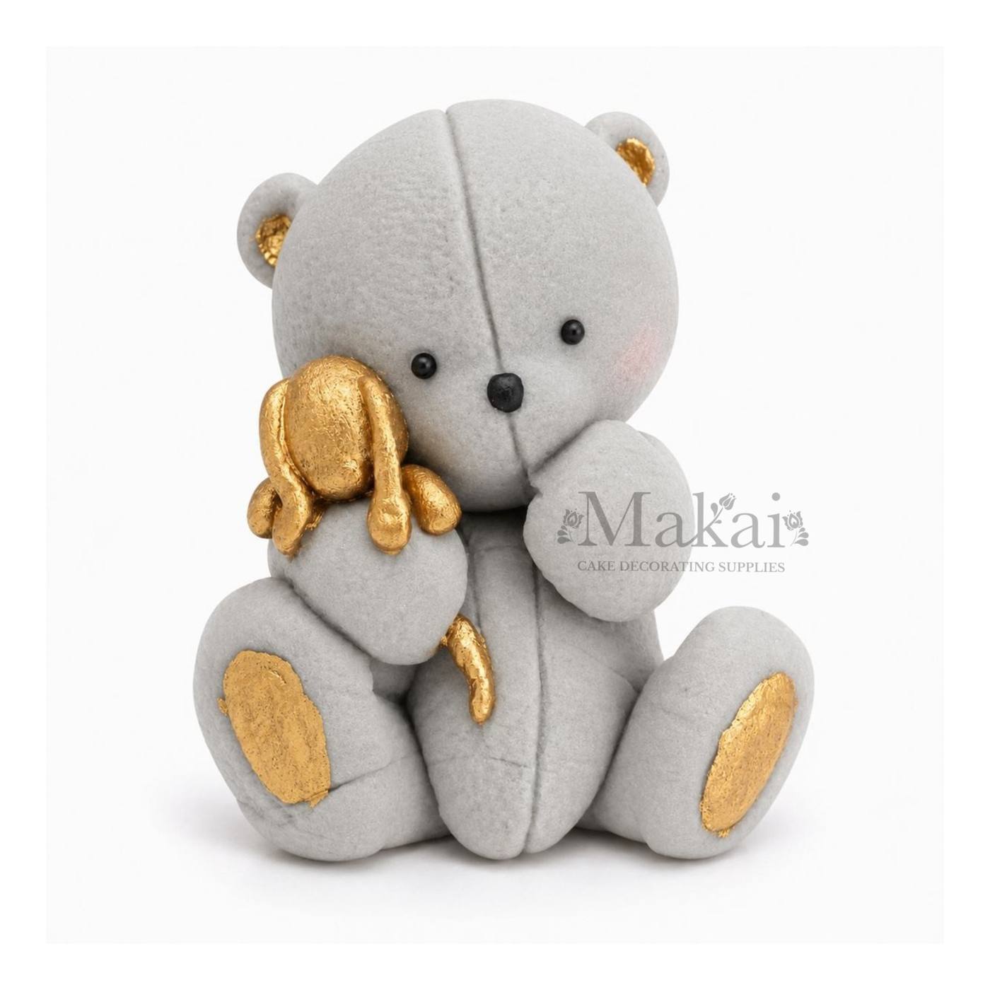 Grey teddy bear fondant cake topper holding a gold bunny decoration, front view