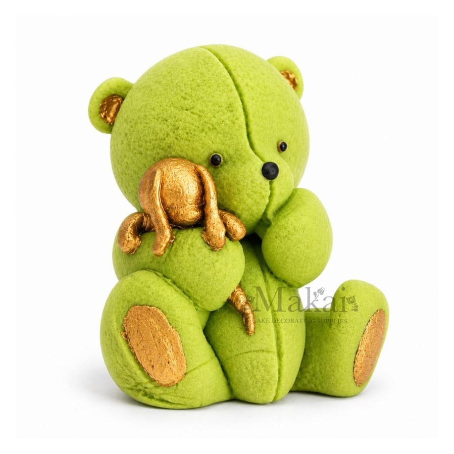 Light Green teddy bear fondant cake topper holding a gold bunny decoration, side view