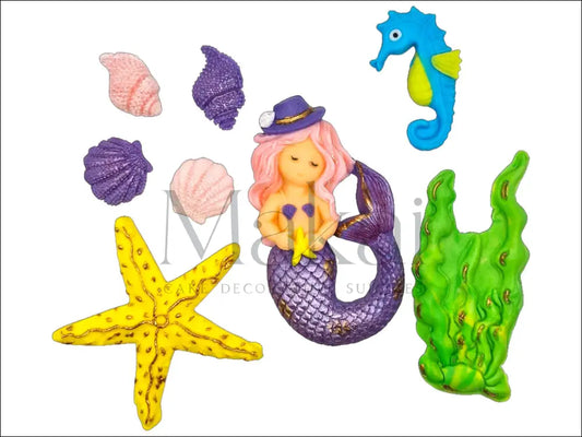 A lilac mermaid cake topper set featuring a mermaid with a matching hat, seashells, a starfish, aquatic plants, and a blue seahorse for an ocean-themed cake.