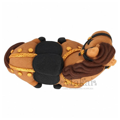 Top view of handmade fondant horse cake topper with black saddle, brown mane and elegant gold decorations.