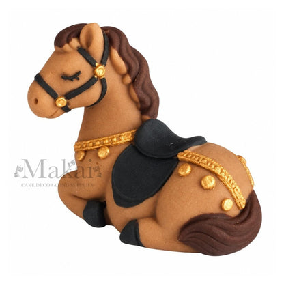 Handmade edible fondant horse cake decoration with black bridle, saddle and gold details, left side view.