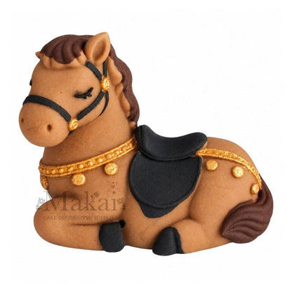 Handmade edible fondant horse cake decoration with brown mane, black saddle and gold detailing, side view.