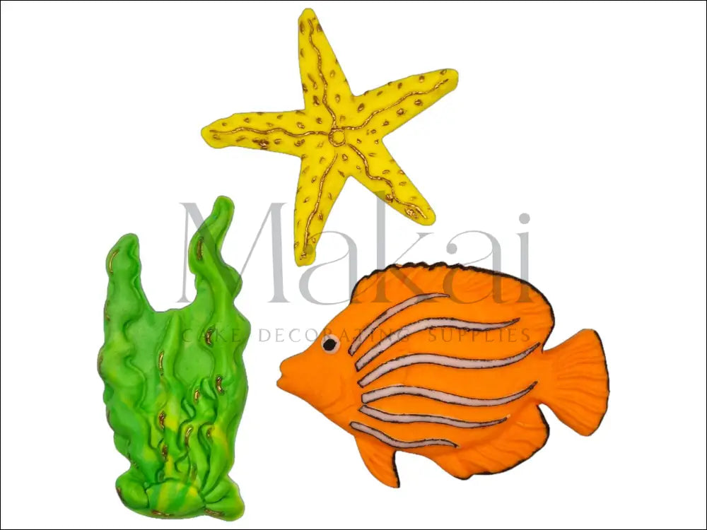 A bright orange fish with black stripes, a golden starfish, and green seaweed fondant cake toppers, perfect for under-the-sea cake decorations.