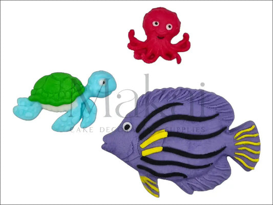 A purple fish, a blue-green sea turtle, and a pink octopus fondant cake topper set, perfect for under-the-sea cake decorations.