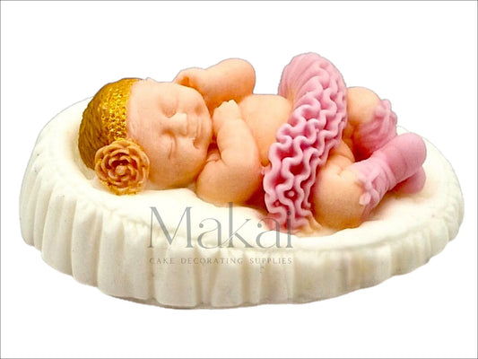 Pink baby girl figurine lying with ruffled skirt and rose headband