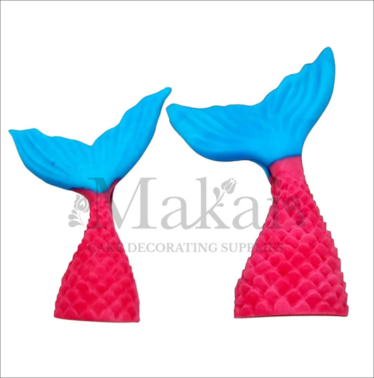 Edible pink and blue mermaid tail toppers, ideal for ocean or fantasy-themed cakes.