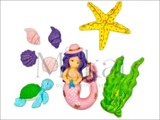 A pink mermaid cake topper set featuring a mermaid with a shimmering tail and hat, seashells, a starfish, aquatic plants, and a blue-toned turtle for an ocean-themed cake.