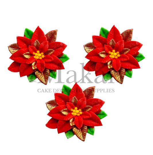 Red poinsettia edible cake toppers with gold leaves and green accents.