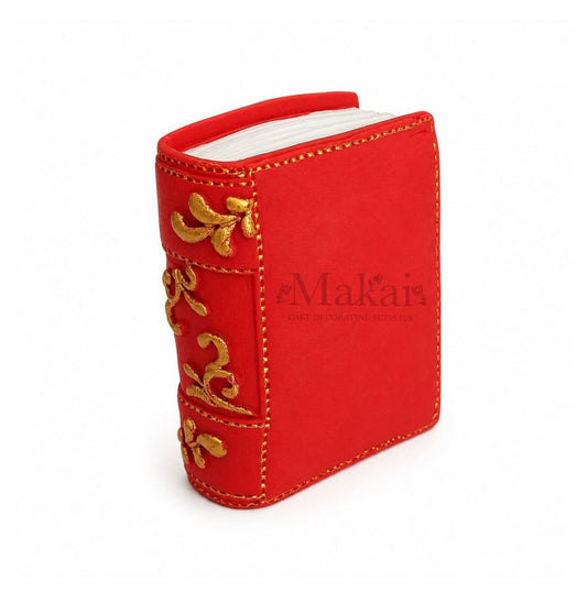 Red edible fantasy book cake topper with gold decorative details